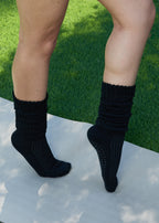 Model wearing the Studio Grip Warmer in Onyx, standing, side view