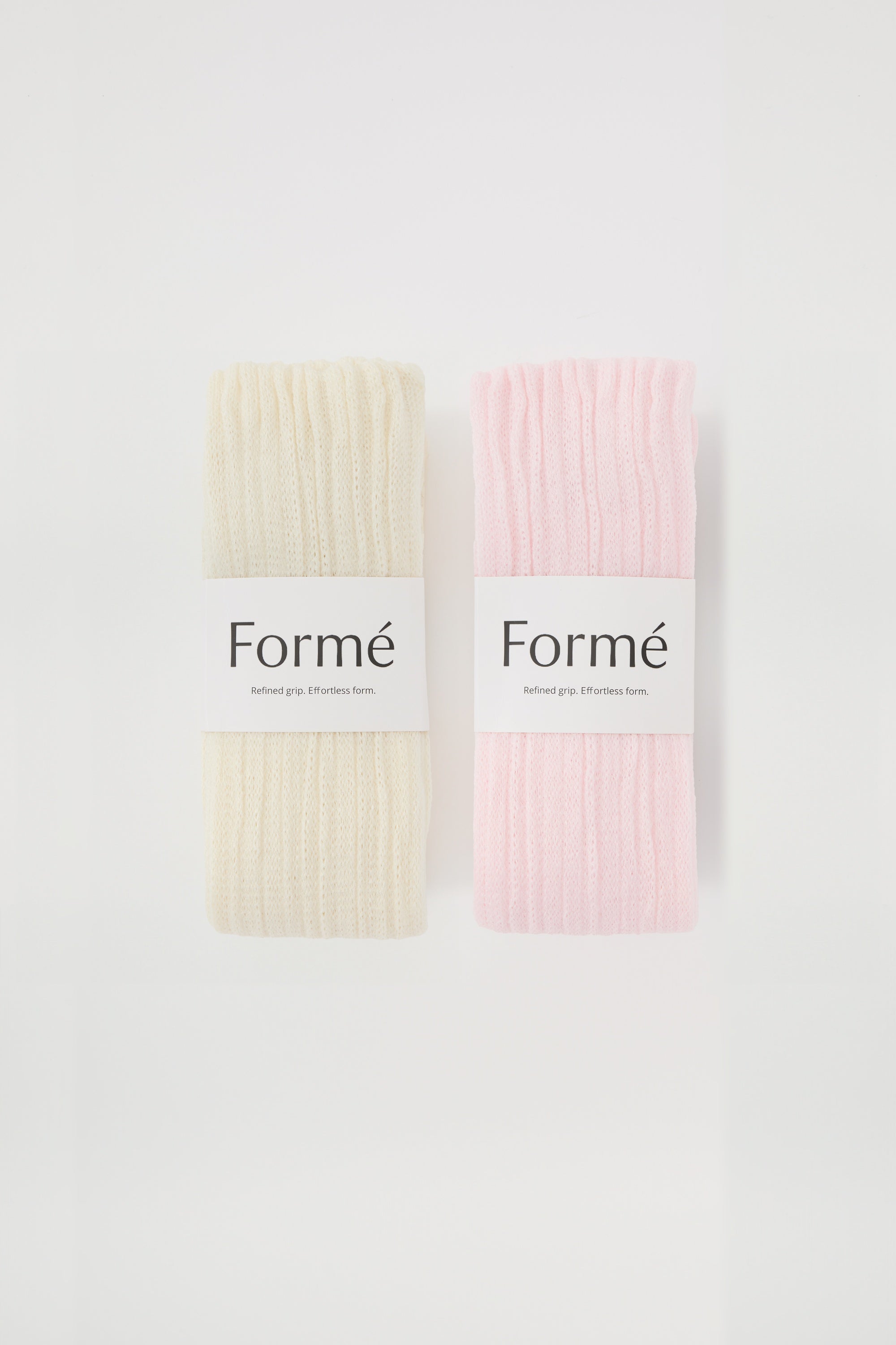 The Duo Set: two pairs of the Formé Studio Grip Warmer in Ivory and Blush, packaged flat-lay