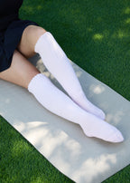 Model wearing the Studio Grip Warmer in Blush, pulled up, seated